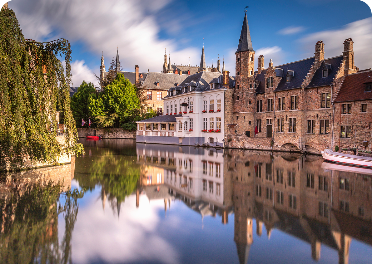 Historic buildings reflected in calm canal water.