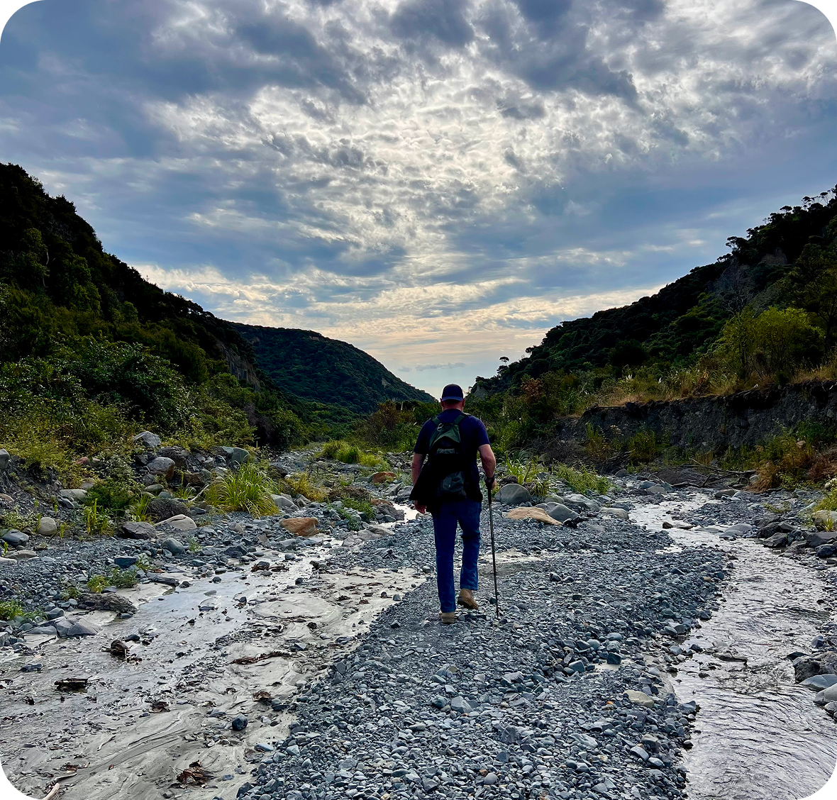 Hiker walking through rocky mountain landscape.
